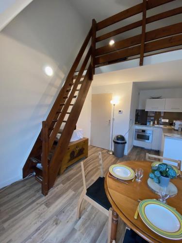 - une cuisine et une salle à manger avec une table en bois et des escaliers dans l'établissement L appart 516, à Villers-sur-Mer