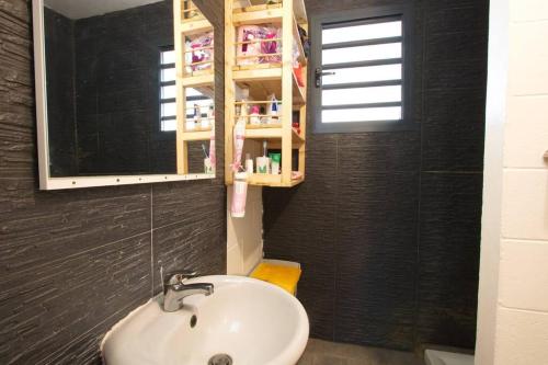 a bathroom with a sink and a mirror at Kaz Nomia - à 50m de la plage Roches Noires in Saint-Gilles les Bains