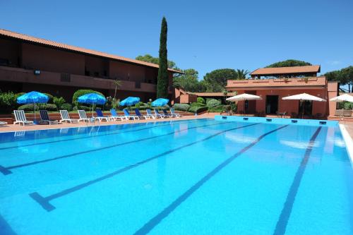 a large swimming pool with chairs and umbrellas at Hotel Residence Villa San Giovanni in Portoferraio
