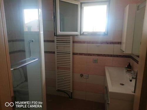 baño con ducha, lavabo y ventana en Ducky House, en Preveza
