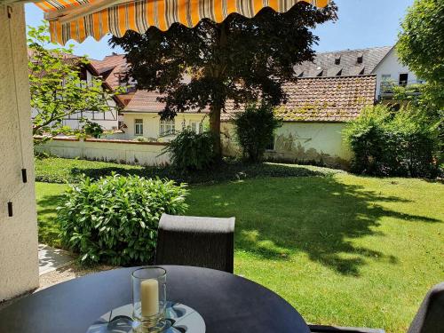 a table with a wine glass on top of a yard at Ferienwohnung Stadler in Langenargen