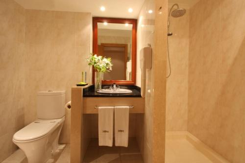 uma casa de banho com um WC, um lavatório e um espelho. em Habana Motel em Matosinhos