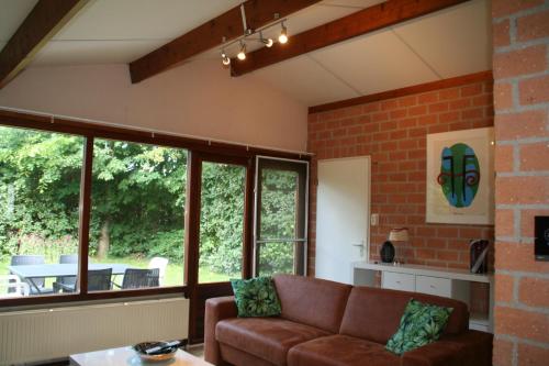 sala de estar con sofá y algunas ventanas en Rekerlanden 173 en Schoorldam