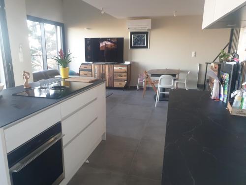 une cuisine avec un comptoir noir et une table dans l'établissement à la cime du mont Saint Clair, à Sète