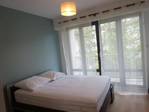 - une chambre avec un lit en face d'une fenêtre dans l'établissement Appartement T2 avec place de parking, à Bayonne