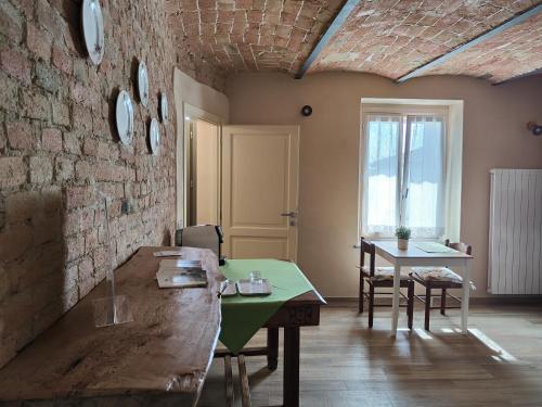 a room with a table and a brick wall at Bricco - Bed&Breakfast in Murisengo