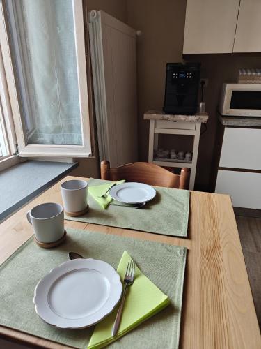 a table with white plates and utensils on it at Bricco - Bed&Breakfast in Murisengo
