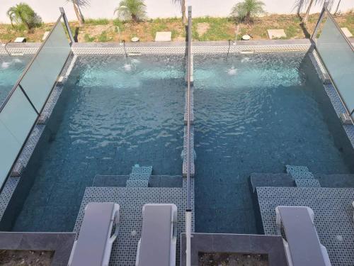 a swimming pool with chairs in the water at Paradise Garden in Kolimbia