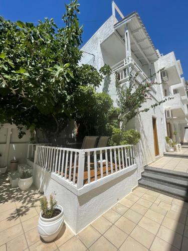 a white house with a white railing and trees at Matala View in Matala