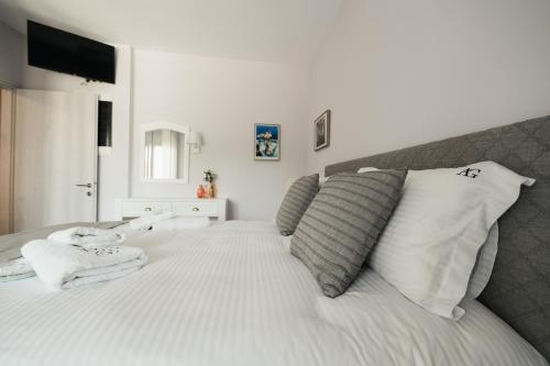 a bedroom with a large white bed with white pillows at Onar Village Luxury Apartments in Kavala