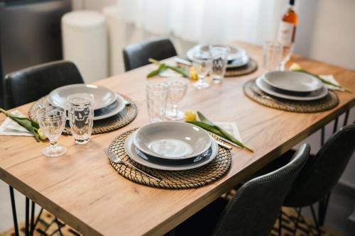 a wooden table with plates and glasses on it at Onar Village Luxury Apartments in Kavala