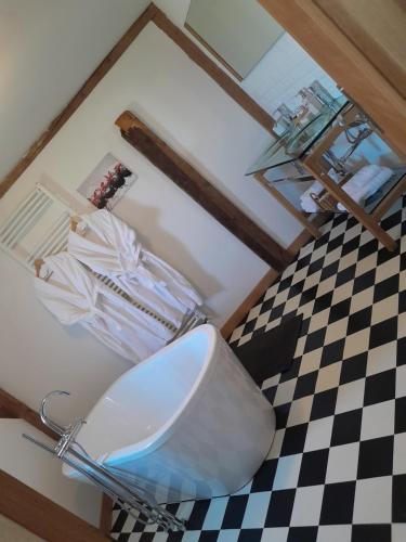 a bathroom with a toilet and a checkered floor at Les gites de l'étang in Champdray