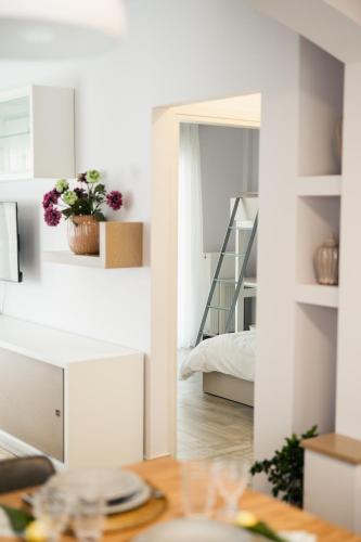 a living room with a table and a bedroom at Onar Village Luxury Apartments in Kavala