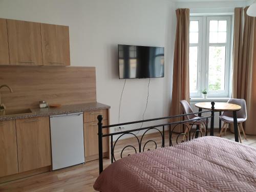 1 dormitorio con 1 cama y cocina con mesa en Apartamenty Dora, en Sopot