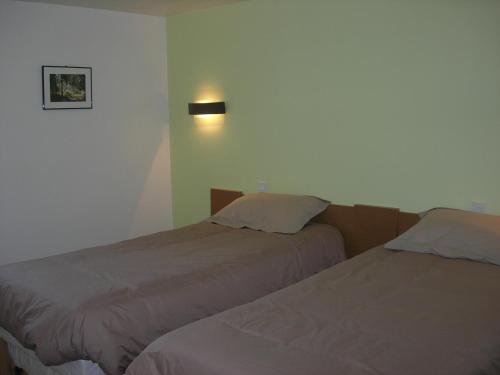 a bedroom with two beds and a light on the wall at ancien moulin à eau entièrement rénové in Prat