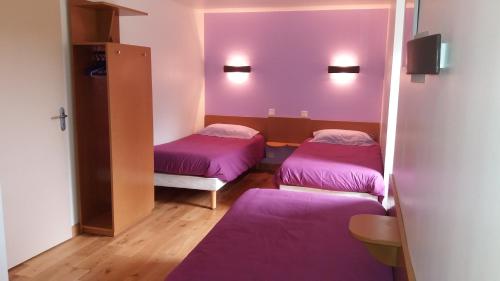 two beds in a room with purple walls at ancien moulin à eau entièrement rénové in Prat