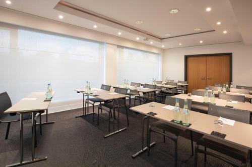 a classroom with tables and chairs and a large window at Holiday Inn Munich - Leuchtenbergring by IHG in Munich