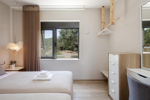 a white bedroom with a bed and a window at Villa Veni in Kolymvari