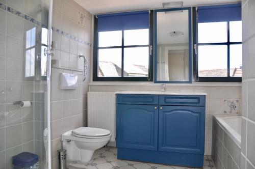 baño con armario azul y aseo en Buitenplaats 86, en Callantsoog