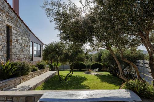 a garden with trees and a stone wall at Villa Veni in Kolymvari