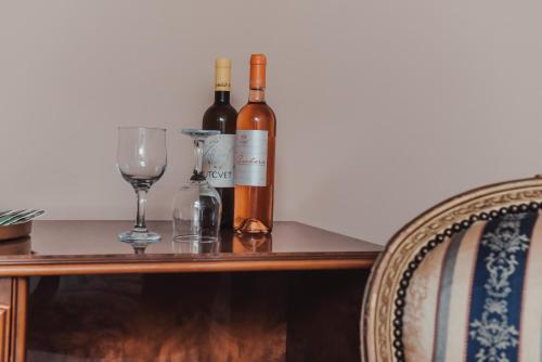 two bottles of wine and a glass on a table at Villa 1880 in Sremski Karlovci