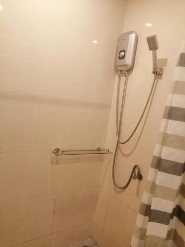 a bathroom with a shower with a phone on the wall at Na Na Twinhouse in Bang Tao Beach