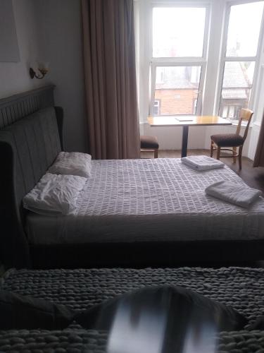 a bedroom with a bed and a window at The Townhouse Self Catering in Dumfries