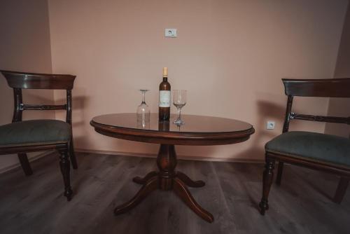 a table with two chairs and a bottle and two glasses at Villa 1880 in Sremski Karlovci