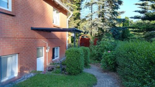 a garden next to a brick house with a walkway at Ferienwohnung Ahoi in Putbus
