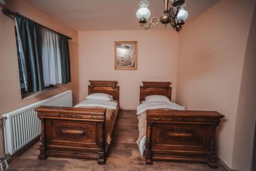 a bedroom with two beds and a chandelier at Villa 1880 in Sremski Karlovci