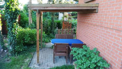 a patio with a blue table and chairs under an umbrella at Ferienwohnung Ahoi in Putbus