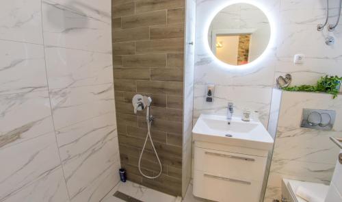 a bathroom with a shower and a sink and a mirror at Apartment Neretva Magic Dream in Mostar