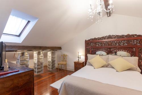 a bedroom with a large bed and a chandelier at Vizcaya Bridge & Beach in Getxo