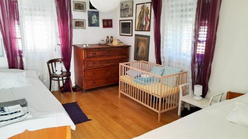 a bedroom with two beds and a crib and a dresser at Rustic Holiday Home Miketa in Lukoran