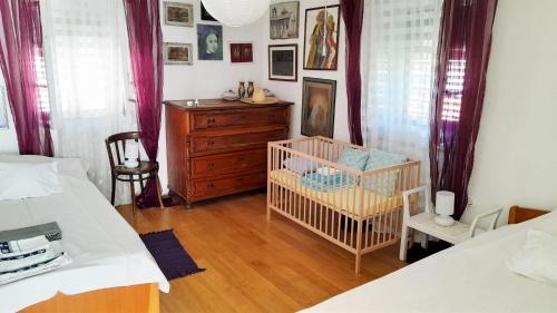 sypialnia z 2 łóżkami i łóżeczkiem dziecięcym oraz komodą w obiekcie Rustic Holiday Home Miketa w mieście Lukoran