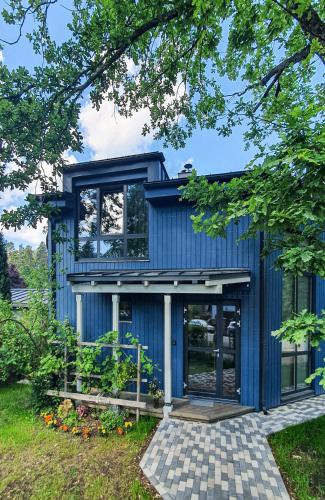 una casa azul con revestimiento azul en Kotedža “Saules osta”, en Saulkrasti
