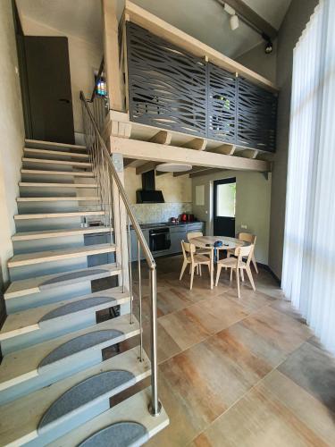 Una escalera en una habitación con una mesa y una cocina. en Kotedža “Saules osta”, en Saulkrasti