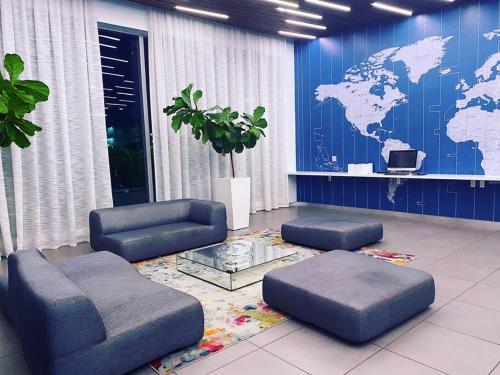a room with a blue wall with a map of the world at Sunlit BeachWalk Studio 2 Full Beds Coastal Charm -26B in Hallandale Beach