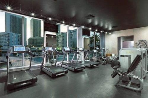 a gym with several treadmills and elliptical machines at Sunlit BeachWalk Studio 2 Full Beds Coastal Charm -26B in Hallandale Beach