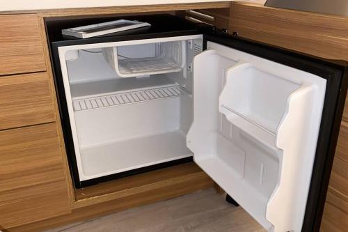 an empty refrigerator with its door open in a kitchen at Sunlit BeachWalk Studio 2 Full Beds Coastal Charm -26B in Hallandale Beach