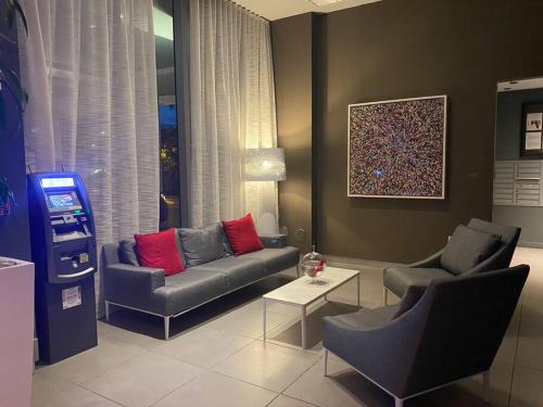a living room with a couch and two chairs at Sunlit BeachWalk Studio 2 Full Beds Coastal Charm -26B in Hallandale Beach