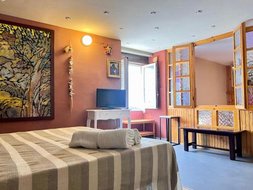 1 dormitorio con 1 cama y TV. en B&B Borgo, en Ventimiglia