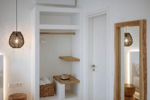 a room with a white wall with two pendant lights at Nautica Suites-Superior Seaview suite with jacuzzi in Antiparos Town