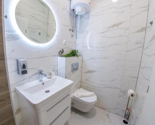 a white bathroom with a sink and a toilet at Apartment Neretva Magic Dream in Mostar