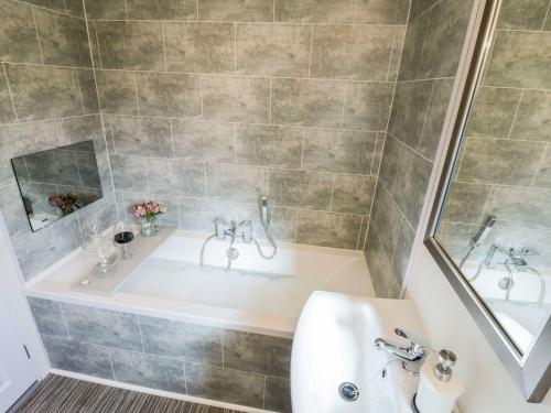 a bathroom with a tub and a sink at Rockpool Retreat in Saltburn-by-the-Sea