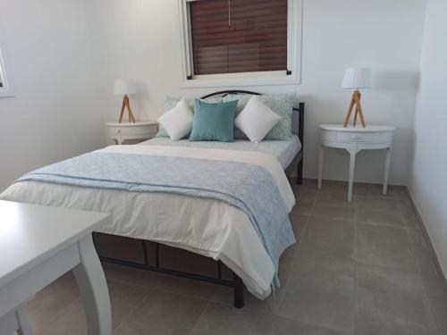 a bedroom with a bed and a table and a window at Seaview Mini Villa with Private Pool - 200 metres from the beach in Perama