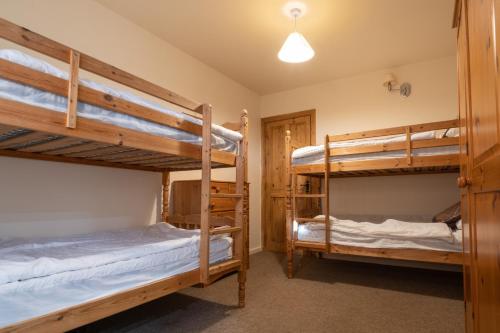 a bedroom with two bunk beds in a cabin at The Holmes Barn - Sleeps 16 - Pet friendly in Buxton