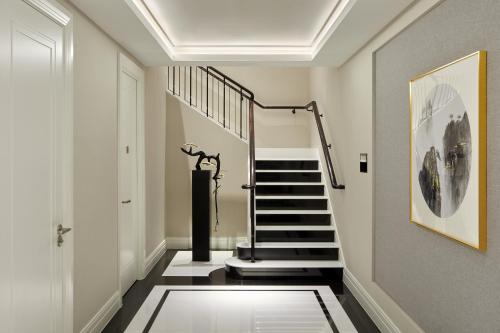 a hallway with a spiral staircase with a stair at Four Seasons Hotel London at Tower Bridge in London