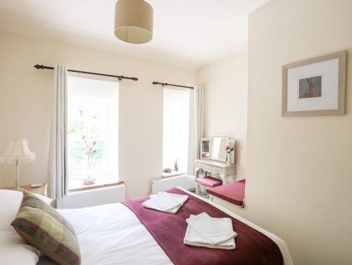 Un dormitorio con una cama con toallas. en Llys Elen, en Caernarfon