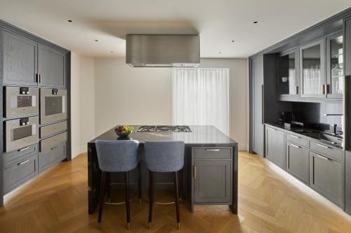 a kitchen with a island with two bar stools at Four Seasons Hotel London at Tower Bridge in London